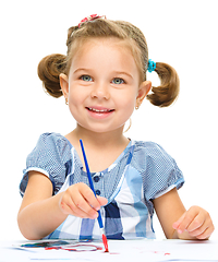 Image showing Little girl is painting with gouache