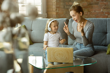 Image showing Teacher and little girl, or mom and daughter. Homeschooling concept