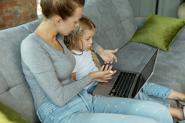 Image showing Teacher and little girl, or mom and daughter. Homeschooling concept