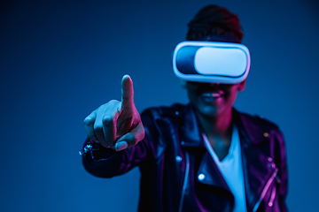 Image showing Young african-american woman\'s using VR-glasses in neon light