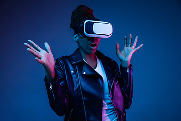 Image showing Young african-american woman\'s using VR-glasses in neon light