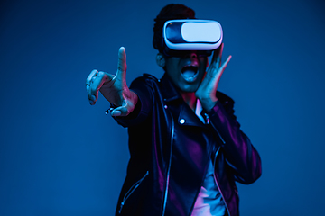 Image showing Young african-american woman\'s using VR-glasses in neon light