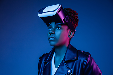 Image showing Young african-american woman\'s using VR-glasses in neon light