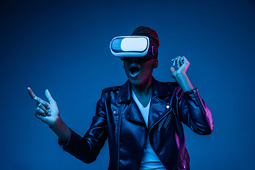 Image showing Young african-american woman\'s using VR-glasses in neon light