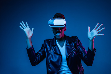 Image showing Young african-american woman\'s using VR-glasses in neon light