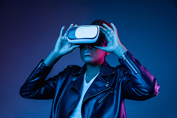 Image showing Young african-american woman\'s using VR-glasses in neon light