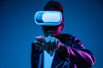 Image showing Young african-american woman\'s using VR-glasses in neon light