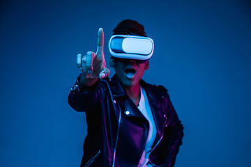 Image showing Young african-american woman\'s using VR-glasses in neon light