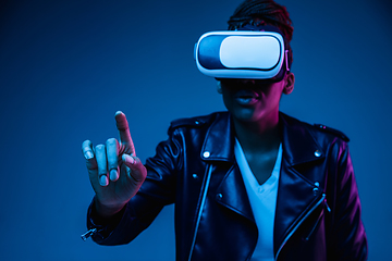 Image showing Young african-american woman\'s using VR-glasses in neon light