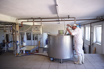 Image showing Cheese production cheesemaker working in factory