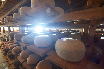 Image showing Cheese factory production shelves with aging old cheese