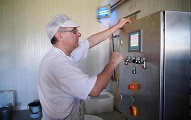 Image showing Cheese production cheesemaker working in factory