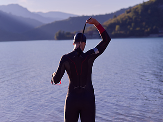 Image showing authentic triathlon athlete getting ready for swimming training on lake