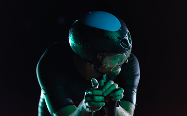 Image showing triathlon athlete riding bike at night