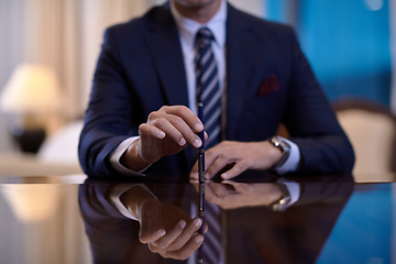 Image showing corporate businessman at luxury office pen holding