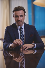 Image showing corporate businessman at luxury office pen holding