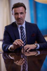 Image showing corporate businessman at luxury office pen holding