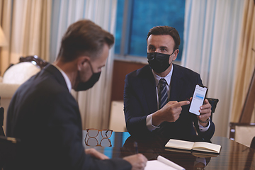 Image showing business people wearing crona virus protection face mask on meeting