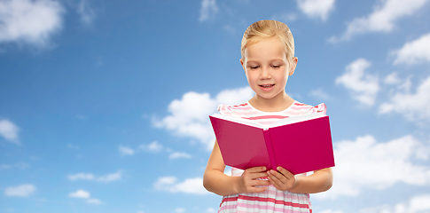Image showing smiling little girl reading book