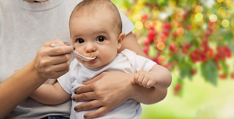 Image showing close up of mother with spoon feeding little baby