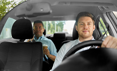 Image showing male taxi driver driving car with passenger