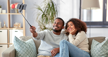 Image showing couple taking picture by selfie stick at home