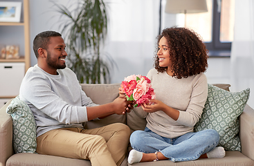 Image showing happy couple with bunch of flowers at home