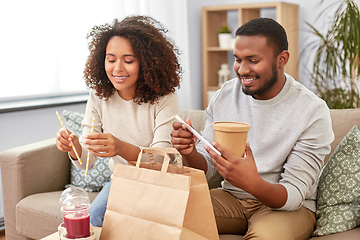 Image showing happy couple with takeaway food and drinks at home