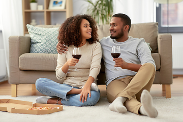 Image showing happy couple with wine and takeaway pizza at home