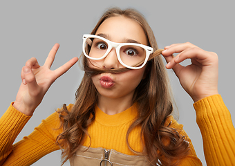 Image showing teen girl in glasses makes faces and shows peace