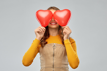 Image showing happy teenage girl with red heart-shaped balloons