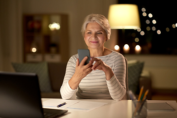 Image showing senior woman with smartphone at home at night