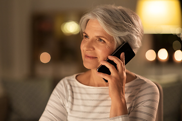 Image showing old woman calling on smartphone at home in evening