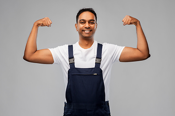 Image showing smiling indian worker or builder showing his power