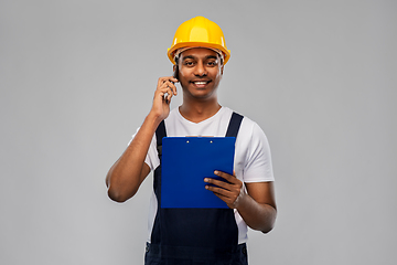 Image showing indian builder with clipboard calling on cellphone