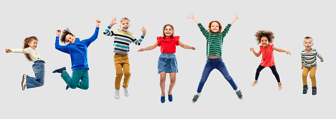 Image showing happy children jumping in air over grey background