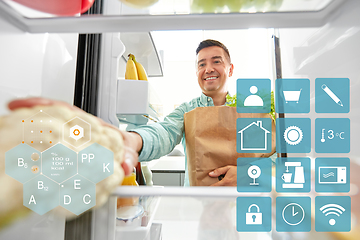 Image showing man putting new purchased food to home fridge