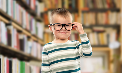 Image showing portrait of smiling boy in glasses over library