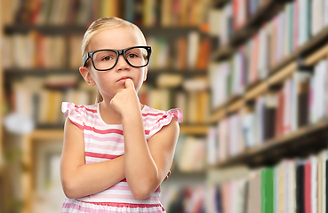 Image showing little girl in black glasses thinking at library