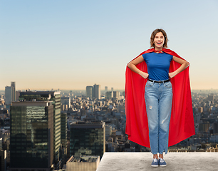 Image showing happy woman in red superhero cape over tokyo city