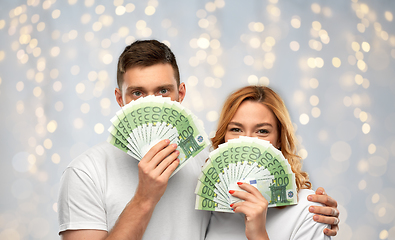 Image showing happy couple in white t-shirts with euro money