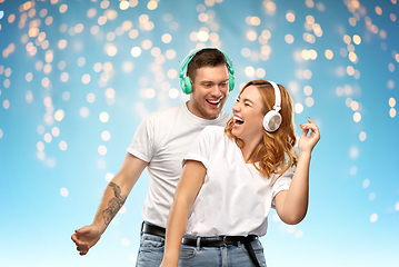 Image showing happy couple in headphones dancing