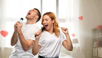 Image showing happy couple singing to hairbrush and lotion