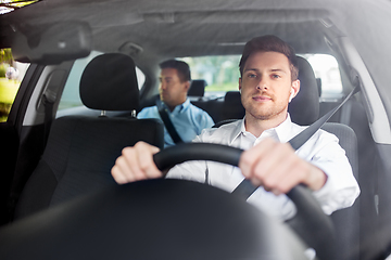 Image showing male driver with wireless earphones driving car