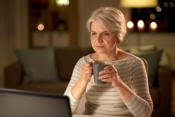 Image showing senior woman with laptop drinking coffee at home