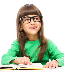 Image showing Little girl is reading a book