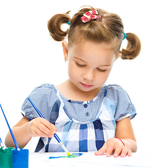 Image showing Little girl is painting with gouache