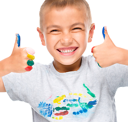 Image showing Portrait of a cute boy playing with paints