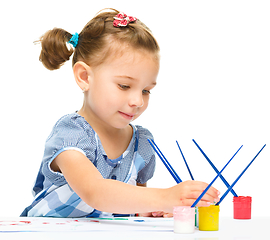 Image showing Little girl is painting with gouache