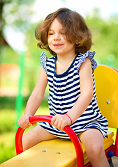 Image showing Young happy girl is swinging in playground